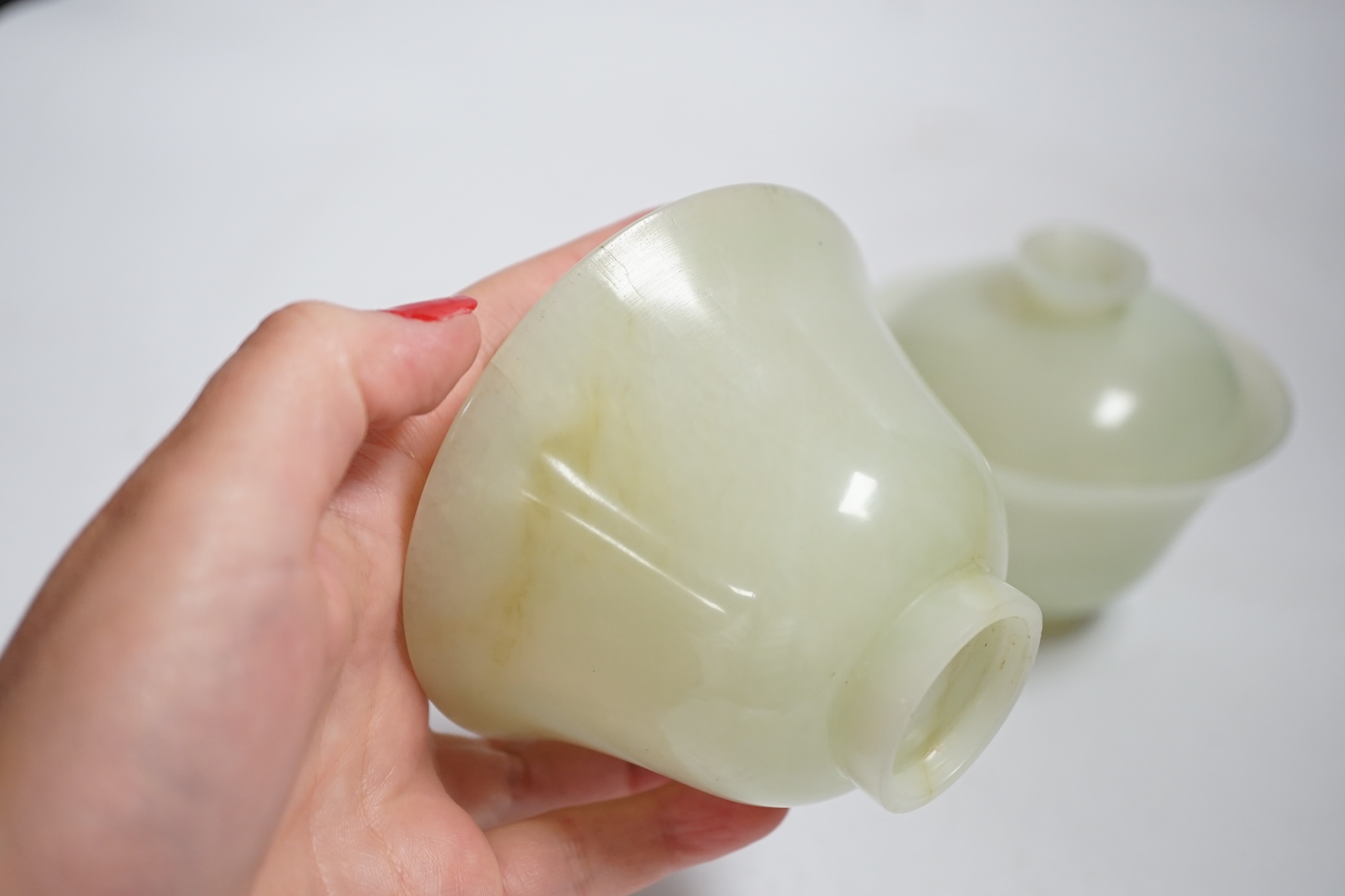 A pair of Chinese bowenite cups and covers, 10cm in diameter